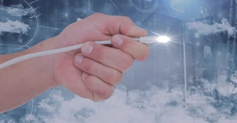 Hand holding computer cable and flare against digitally generated background Stock Photos