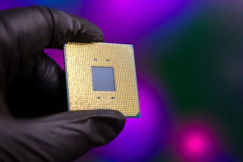 Hand holding a computer chip with colored background and focus on electronic Stock Photos