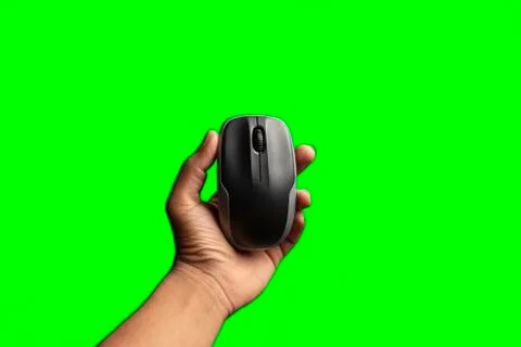 Hand holding computer mouse isolated on the green background. above view of c Stock Photos