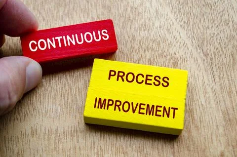Hand holding Continuous Process Improvement text on colored wooden blocks. .. Stock Photos