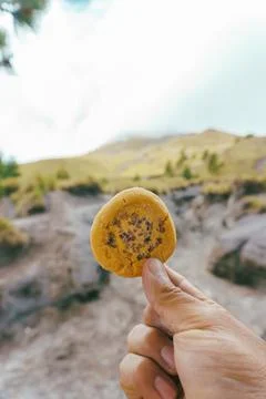 A hand holding a cookie on the mountain Stock Photos
