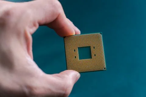 Hand holding CPU. Coonsumer 7 nanometer desktop CPU,  processoor. Informatic  Stock Photos