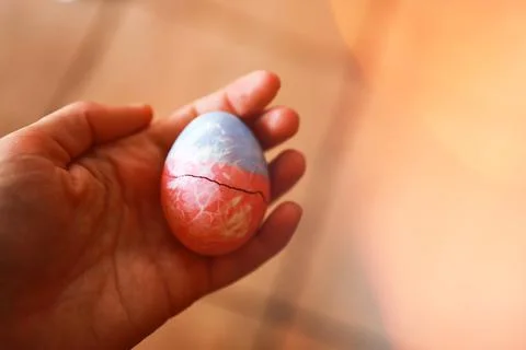 Hand holding cracked Easter egg Stock Photos