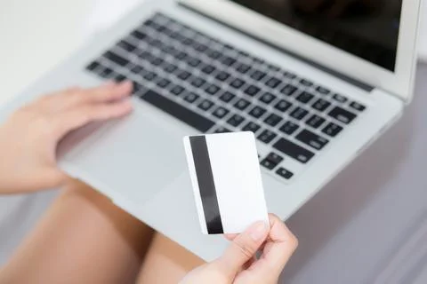 Hand holding credit card using laptop computer shopping online for web e-co.. Stock Photos