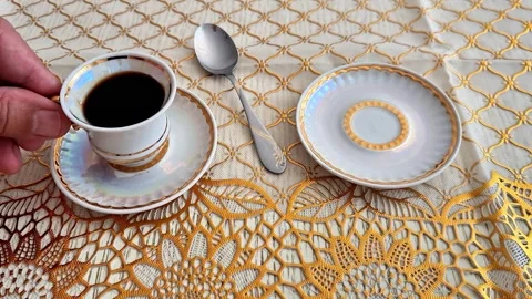 Hand Holding a Cup of Coffee on an Elegant Crochet Tablecloth Vidéo 346743549