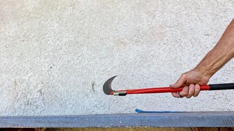 Hand Holding a Curved Braid Tool for Cutting Grass and Vegetation Vídeo Stock 347068013