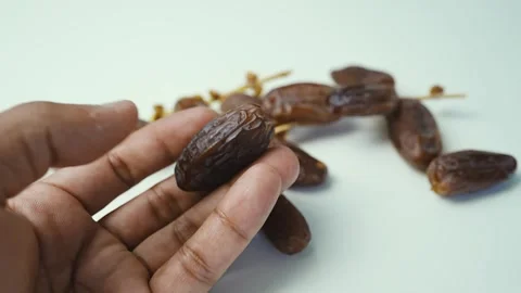Hand Holding Date Fruit Close-Up Shot, Close-up of a hand holding a date fr.. Stockbeeldmateriaal 304974541
