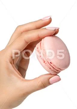 Hand holding delicate pink macaron, french pastry PSD 模板
