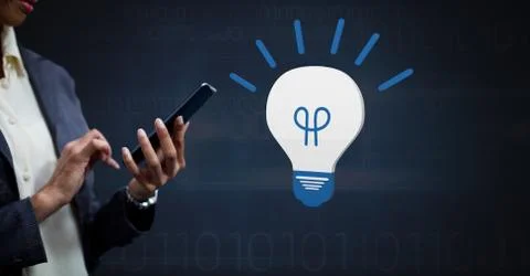 Hand holding device with 3D light bulb idea icon 写真素材