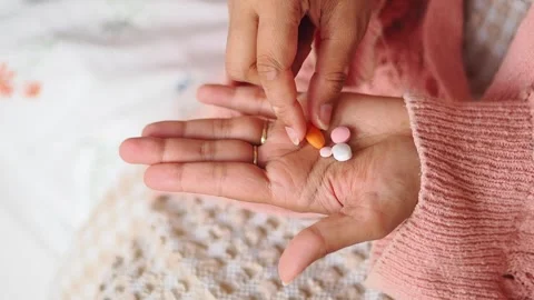 Hand holding different pills on a soft surface Stock Footage 340495690
