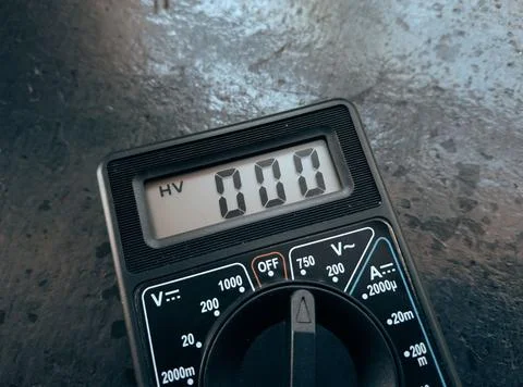 A hand holding a digital multimeter for electrical work Stock Photos