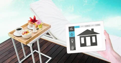 Hand holding digital tablet with smart home application on screen at poolside Stock Photos