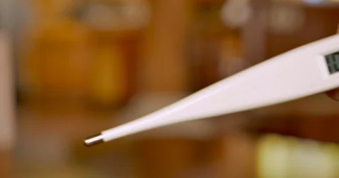 Hand holding a digital thermometer reading 102.2 degrees fahrenheit Video stock 92735931