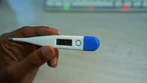 Hand holding digital thermometer with temperature reading, Close-up of a ha.. Stock Footage 346484363