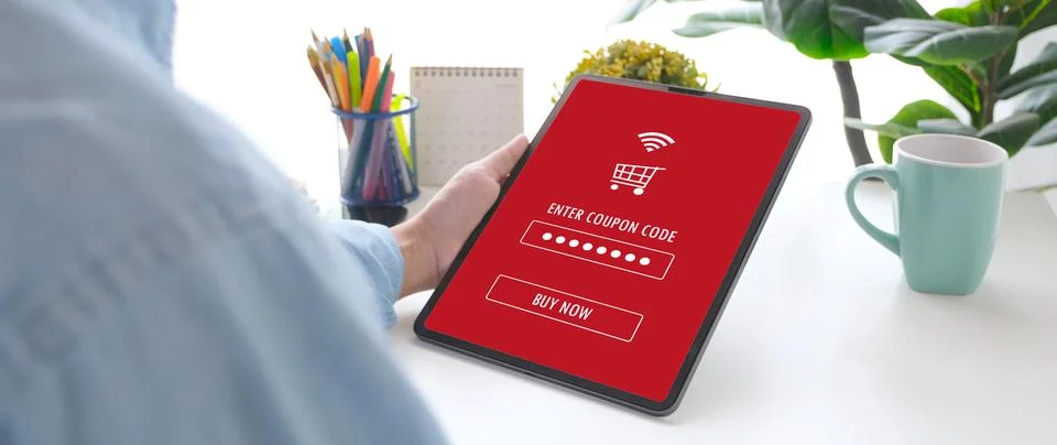 Hand holding discount coupon code on laptop screen to get the shopping on lin Foto stock