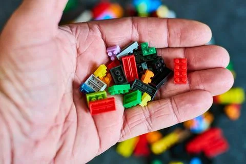 Hand Holding Diverse Bricks - Creative Play Concept 스톡 사진