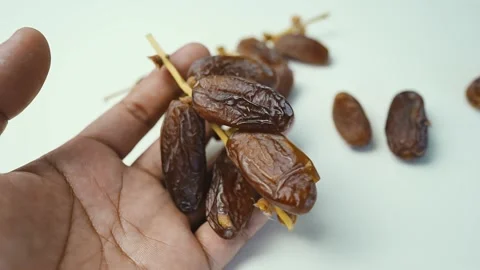 Hand Holding Dried Fresh Dates, A hand holding a bunch of dried dates on a .. Vídeos de archivo 304974574
