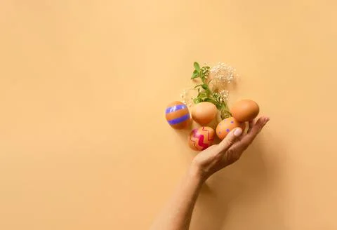 Hand holding easter eggs with greenery, copy space for text, promo or message Stock Photos