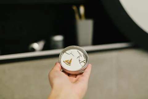 Hand holding eco solid shampoo in metal can in modern bathroom on background  Foto stock