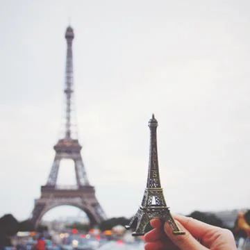Hand holding eiffel tower model in paris, retro filter effect Stock Photos