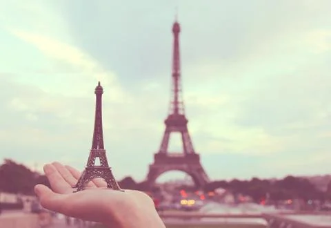 Hand holding eiffel tower model in paris, retro filter effect Foto stock