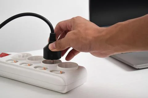 Hand holding electric plug, Multiple socket with connected plugs Stock Photos