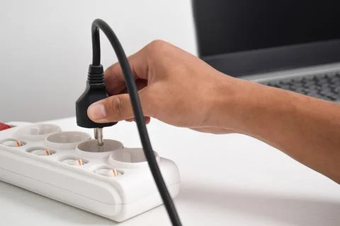 Hand holding electric plug, Multiple socket with connected plugs Stock Photos