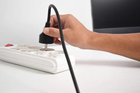 Hand holding electric plug, Multiple socket with connected plugs Stock Photos