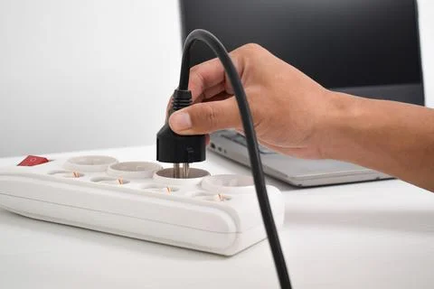Hand holding electric plug, Multiple socket with connected plugs Stock Photos