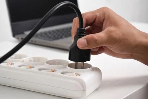 Hand holding electric plug, Multiple socket with connected plugs Stock Photos