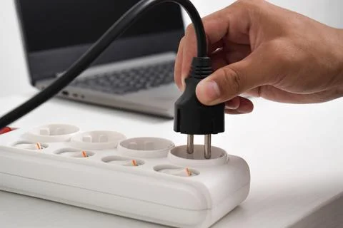 Hand holding electric plug, Multiple socket with connected plugs Stock Photos
