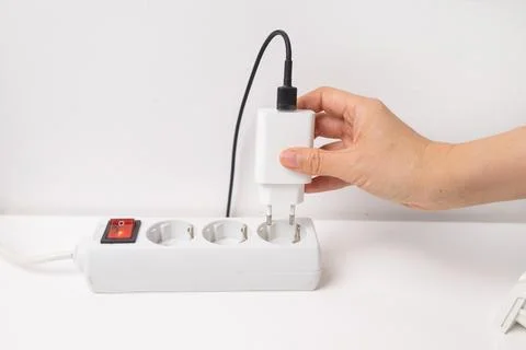 Hand holding electric plug, Multiple socket with connected plugs Stock Photos