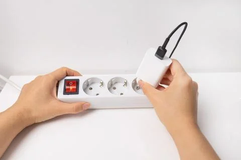 Hand holding electric plug, Multiple socket with connected plugs Stock Photos