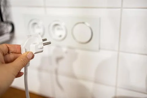 Hand holding electric plug, Multiple socket with connected plugs Stock Photos