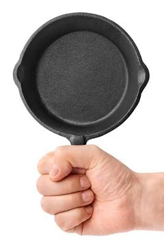 Hand holding empty black cast-iron frying pan Stock Photos