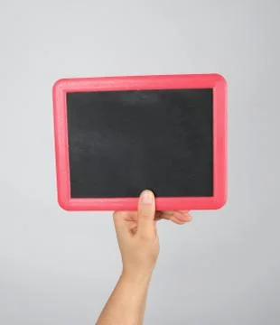 Hand holding an empty chalk frame on a gray background Stock Photos