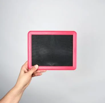 Hand holding an empty chalk frame on a gray background Stock Photos