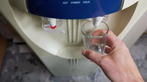 Hand Holding Empty Clear Glass at Office Water Cooler Dispenser Stock Footage 339205974