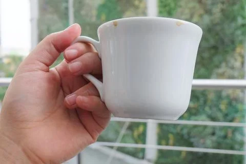 Hand Holding An Empty Cup After Drinking Coffee Stock Photos