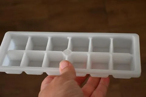 Hand holding an empty ice cube tray Stock Photos