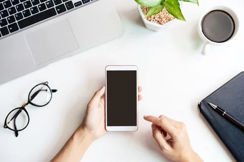 Hand holding empty screen Smart phone on business desk office Fotos Stock