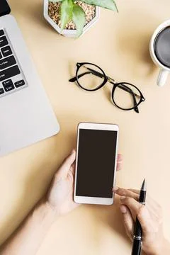 Hand holding empty screen Smart phone on business desk office Fotos Stock