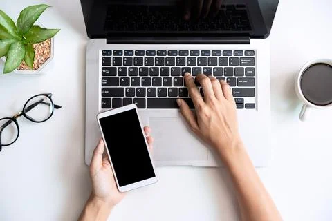 Hand holding empty screen Smart phone on business desk office with copy space Fotos Stock