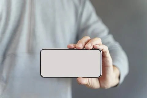 Hand holding empty screen smartphone with clipping path on white screen Stock Photos