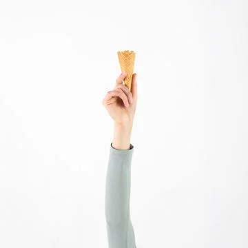 Hand holding empty waffle ice cream cone up Fotos Stock