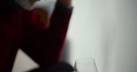Hand holding empty wine glass in soft indoor light Видео 336288764