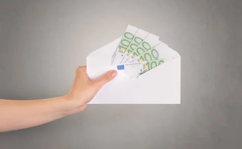 Hand holding envelope with empty wall background Stock Photos