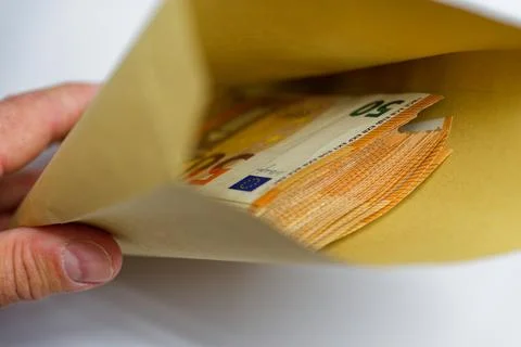 Hand holding envelope with visible stack of 50 euro notes inside Stockfoto's