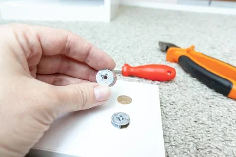 Hand holding fitting, fixing or fastener for mounting assembling furniture ma Stock Photos