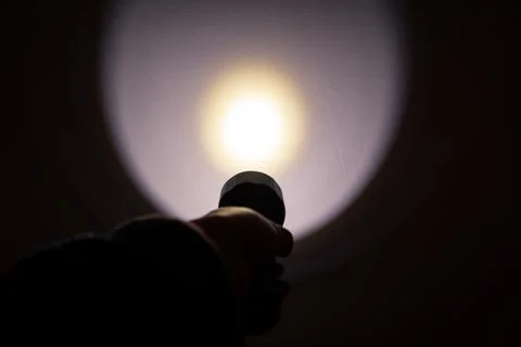 A hand holding a flashlight in the dark Stock Photos